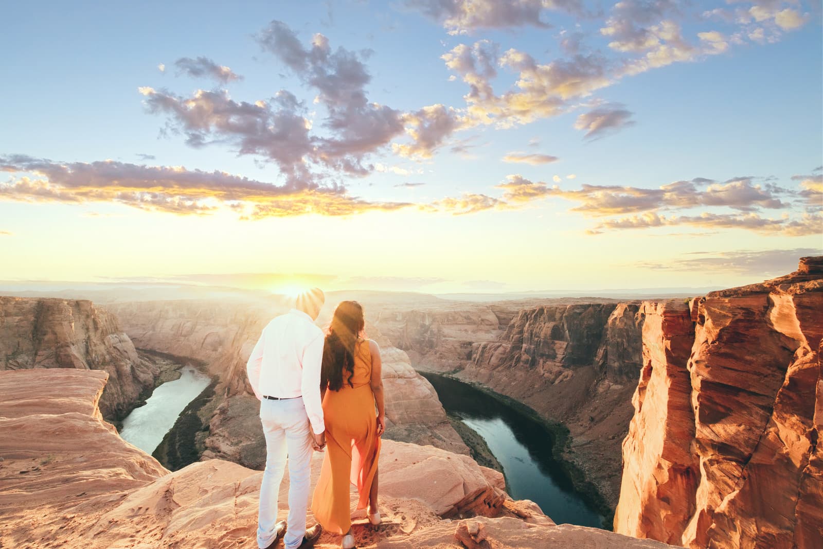 A couple overlooks Horseshoe Bend at sunset