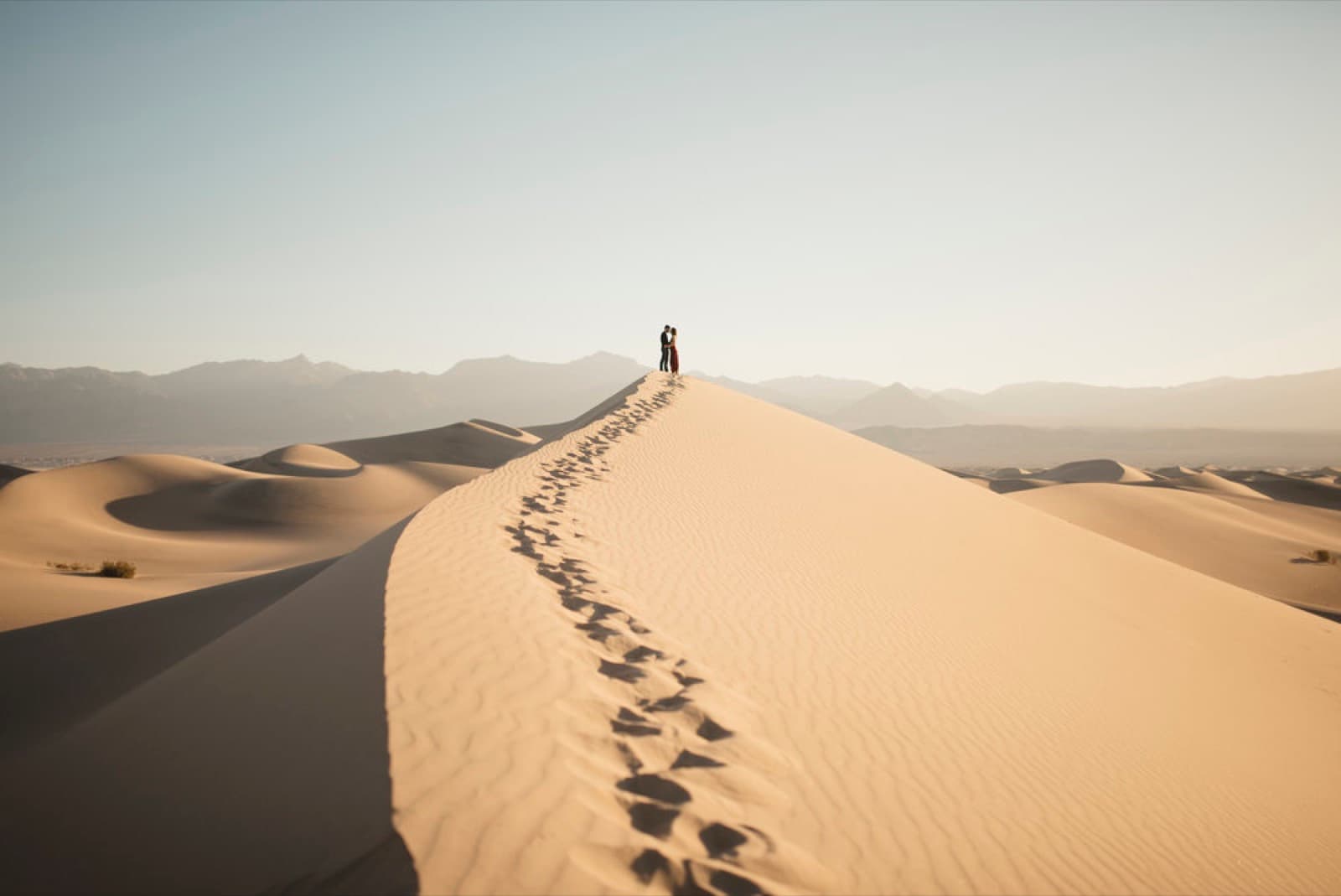 A couple at the crest of a sand dune in Death Valley