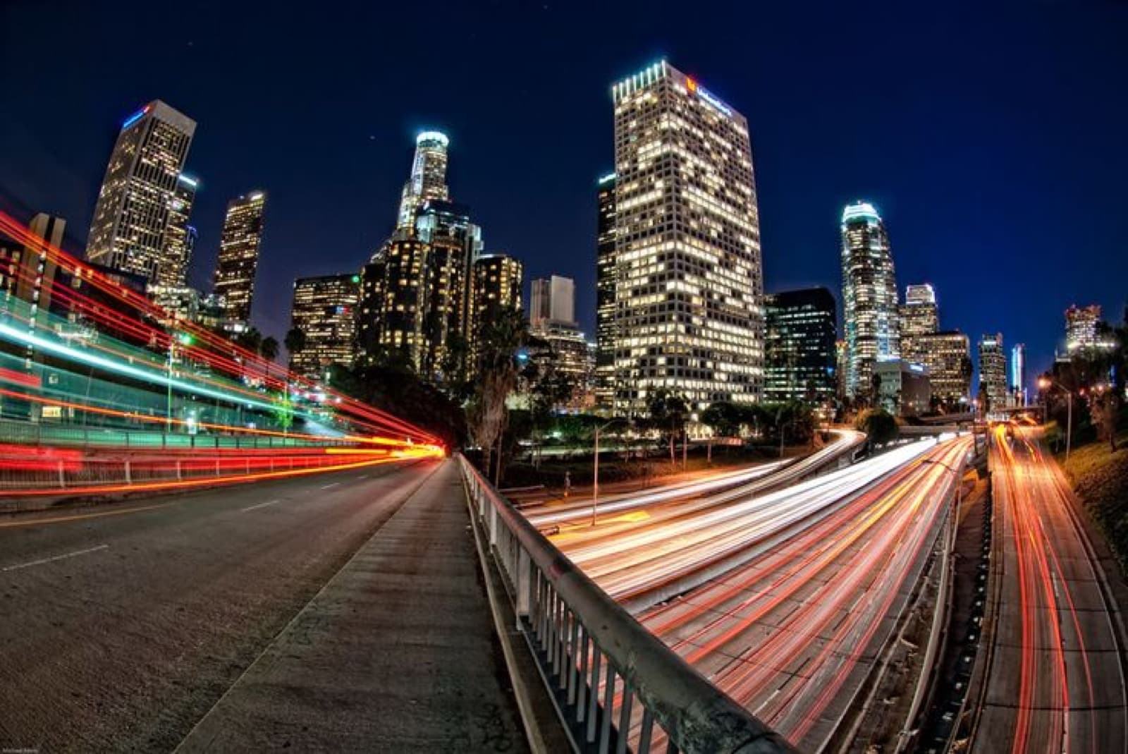 The Downtown Los Angeles skyline at night with freeway light trails
