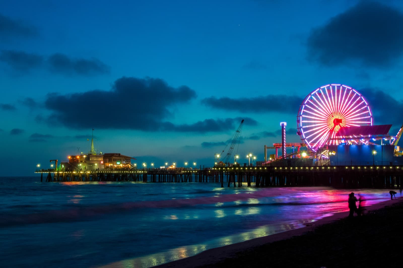 Santa Monica Pier and its Ferris wheel glowing at blue hour