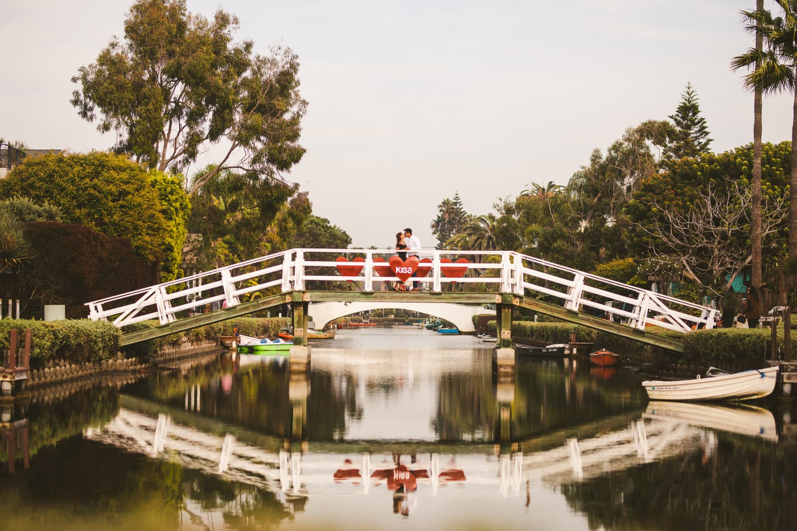 A couple kisses on a Venice Canals footbridge