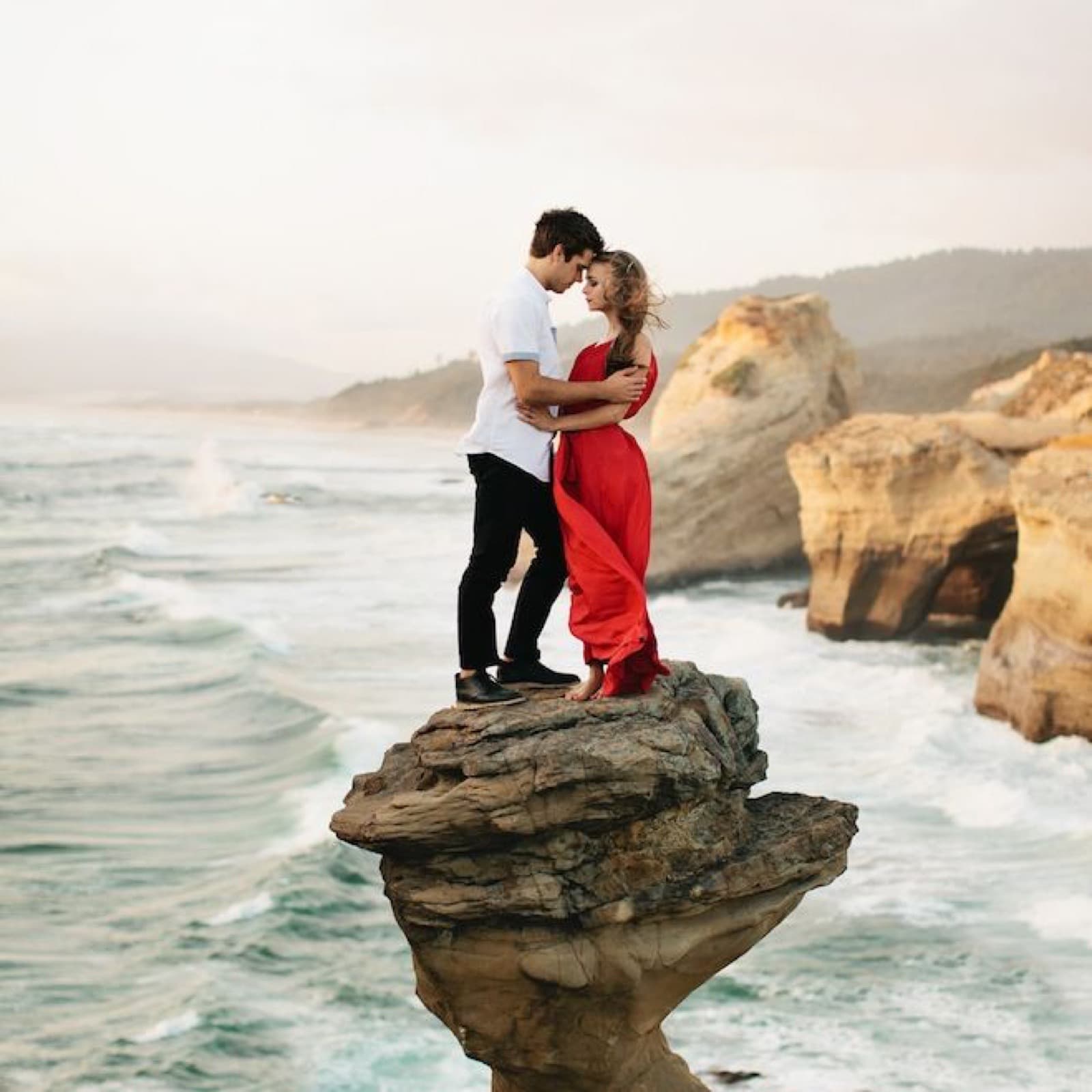 A couple on the rocks at Cape Kiwanda as surf crashes below