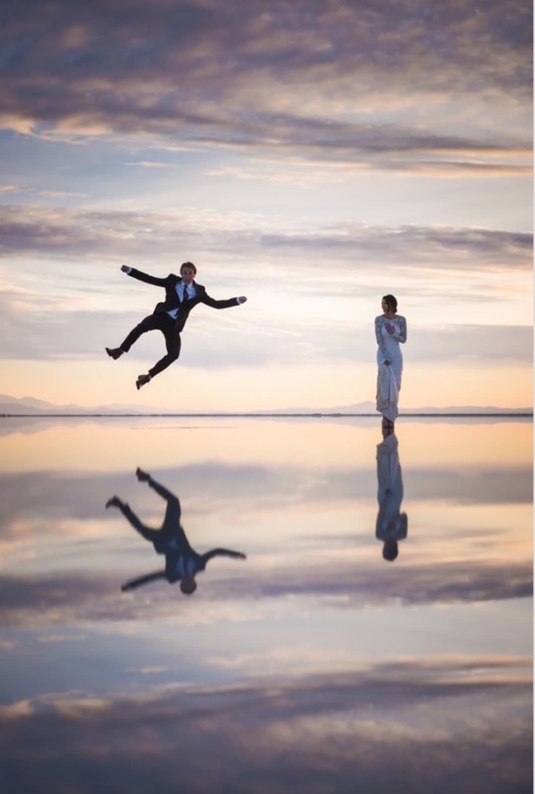A groom leaps beside his bride on the flooded Bonneville Salt Flats